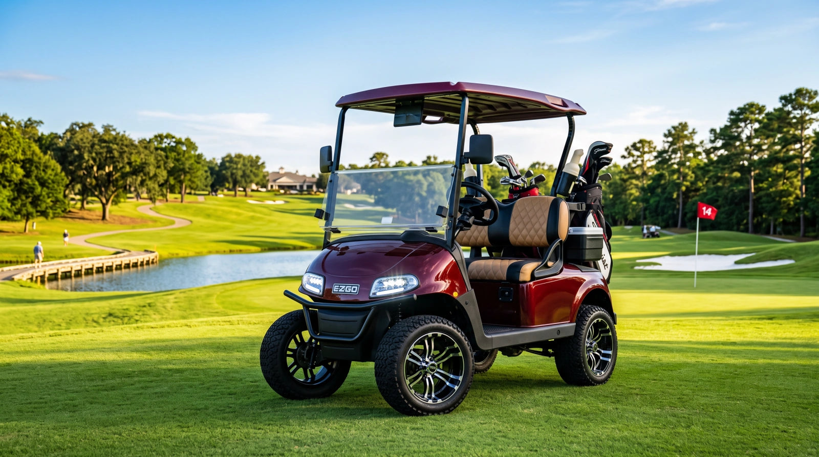 A modern EZGO TXT golf cart is parked on a lush, sunlit golf course fairway, featuring visible upgrades such as LED headlights and custom wheels.
